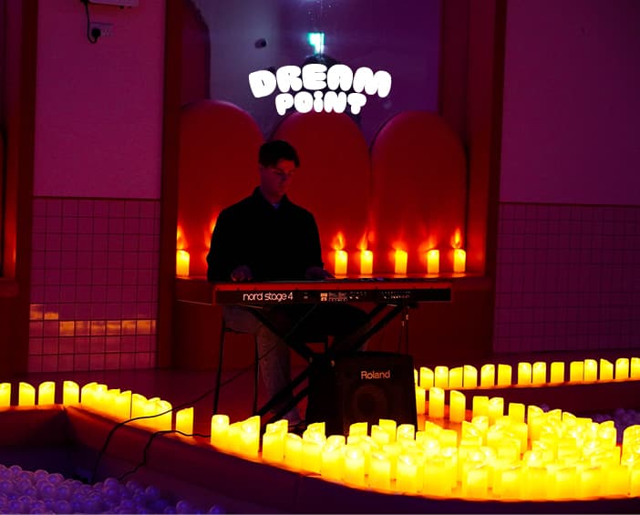 A pianist performing surrounded by candles at a Dream Point Candlelight session