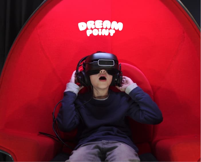 A child wearing a VR headset in a Dream Point VR pod
